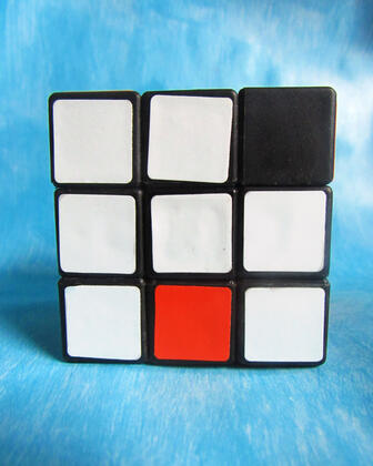 Rubix cube with all white squares, one missing, and one red