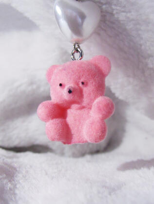 Small earring with a pear-like hear and pink bear with a fluffy white background